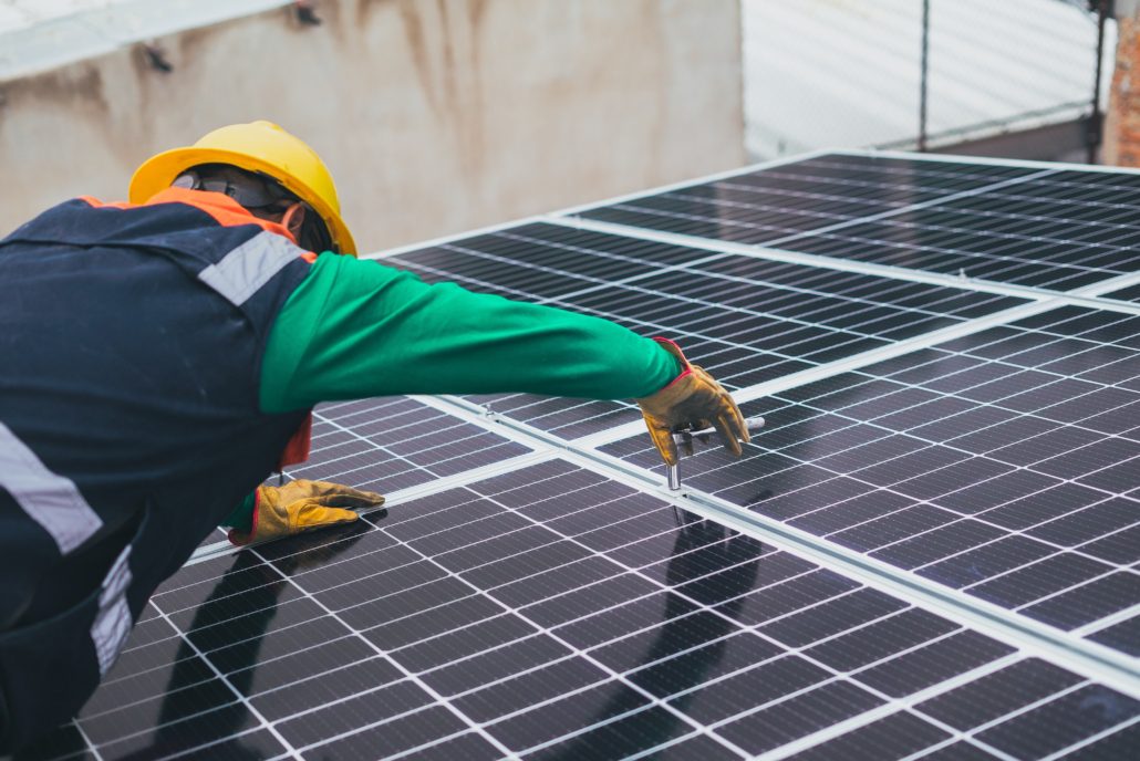 Tehnicien entrain de serrer un écrou pour fixer un panneau solaire